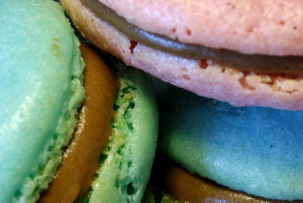 Pastel macarons in close-up, filled shells pressed together
